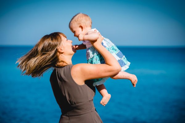 Mama-hebt-kleine-Tochter-hoch-und-dreht-sich-Shooting-am-Strand-Familienfotografie-Fotograf-Rostock - Familienshooting