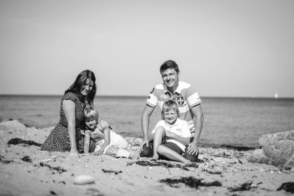 Mutter-und-Vater-sitzen-mit-Tochter-und-Sohn-im-Sand-am-Ostseestrand-Familienglück-Shooting-am-Strand-Familienfotografie-Fotograf-Rostock - Familienshooting
