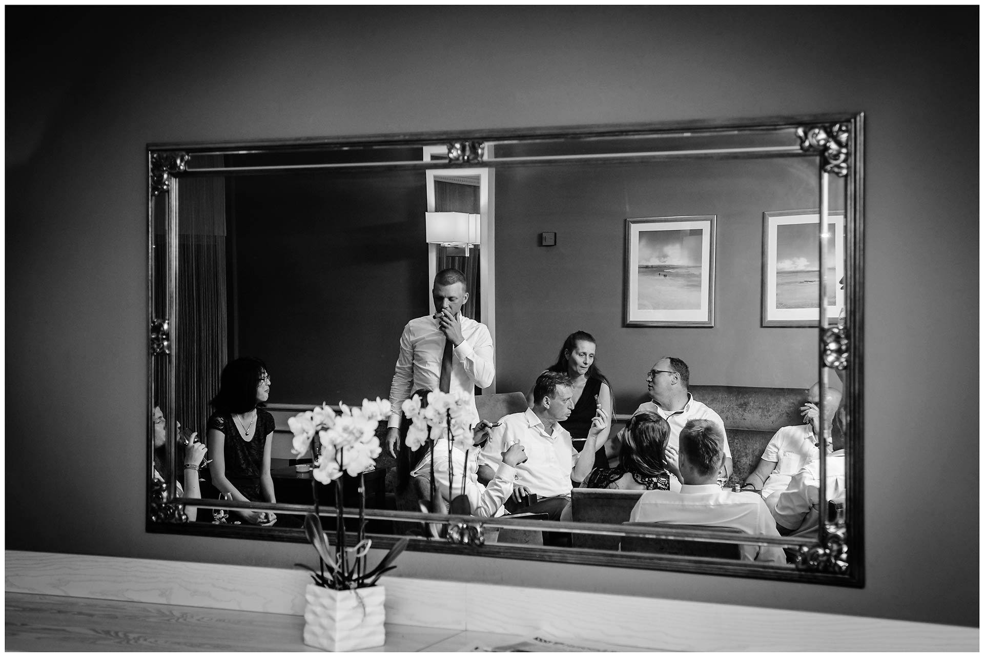 Gäste-der-Hochzeit-sind-in-einem-Spiegel-zu-sehen-und-rauchen-Zigarre-Hochzeit-im-Hotel-Neptun-Hochzeitsfotograf-Warnemuende-Hochzeitsfotograf-Rostock-Hochzeitsfotograf-Ostseebad-Warnemuende