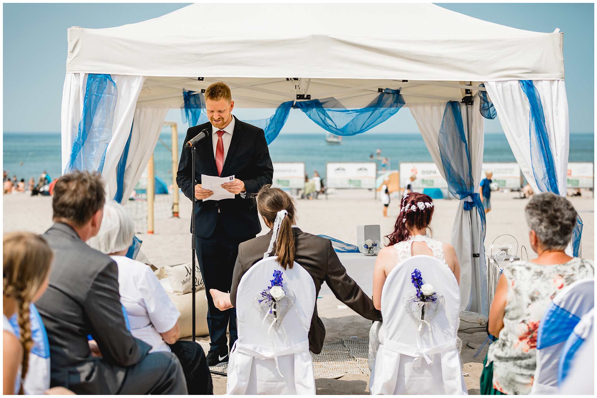 Trauzeuge-haelt-eine-Rede-bei-der-Freien-Trauung-am-Strand-Hochzeit-am-Strand-Hochzeitsfotograf-Warnemuende-Hochzeitsfotograf-Rostock-Hochzeitsfotograf-Ostseebad-Warnemuende