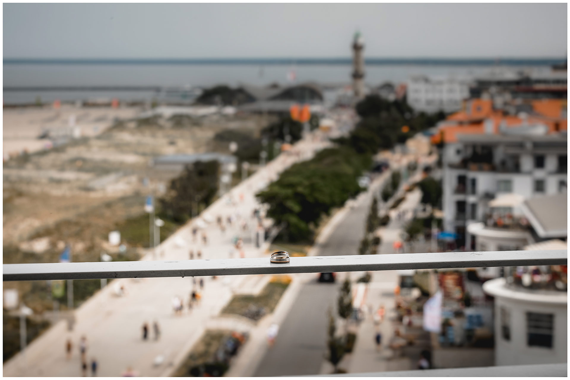 Eheringe-liegen-auf-Balkonbruestung-im-Hintergrund-der-Leuchtturm-von-Warnemuende-Eheringe-liegen-auf-Balkonbrüstung-im-Hintergrund-der-Leuchtturm-von-Warnemuende-Hochzeitsfotograf-Warnemuende-Rostock-Hochzeitsfotograf-Ostseebad-Warnemuende