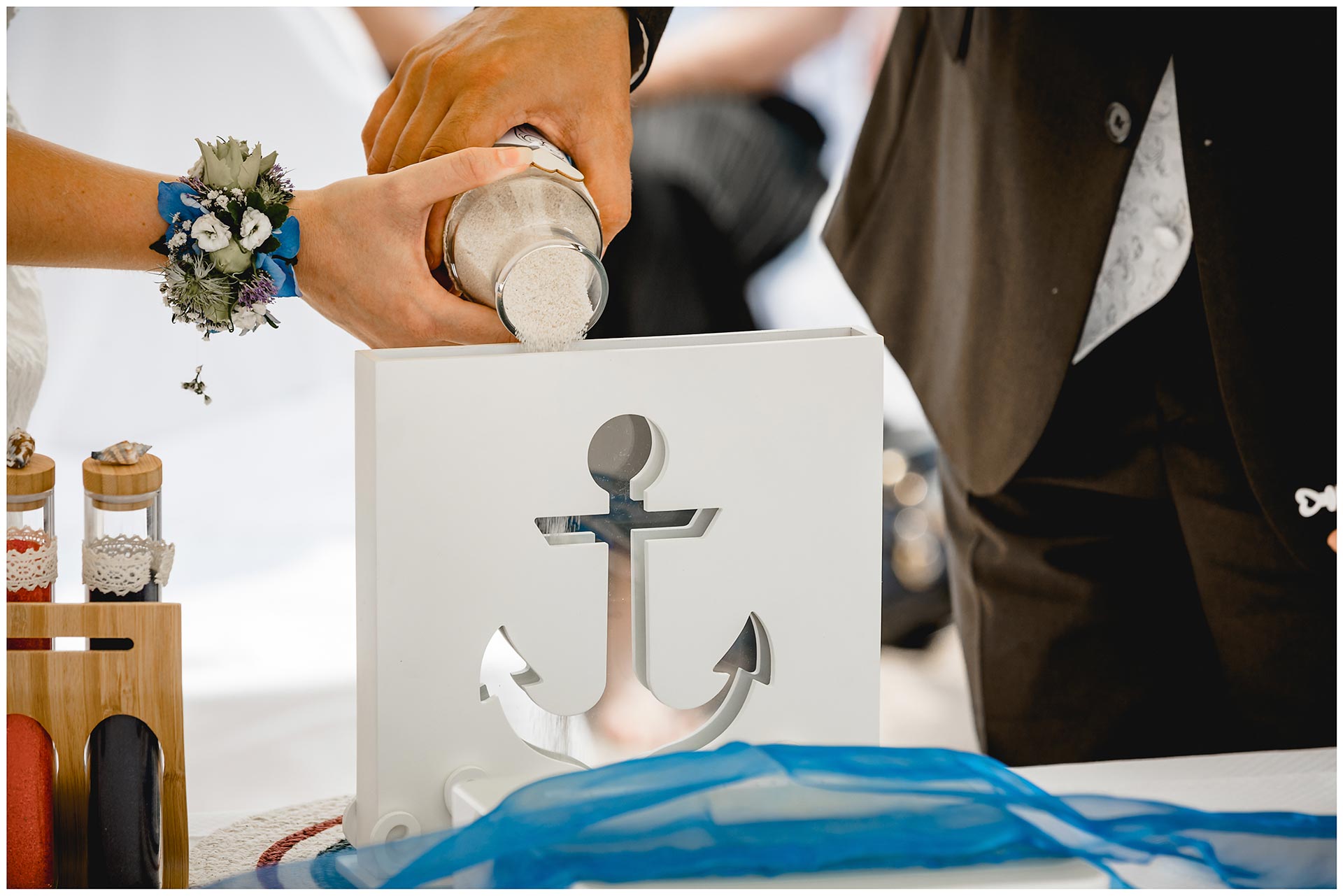 Brautpaar-schuettet-Sand-in-ein-Gefaess_Sandzeremonie-Hochzeit-am-Strand-Hochzeitsfotograf-Warnemuende-Hochzeitsfotograf-Rostock-Hochzeitsfotograf-Ostseebad-Warnemuende