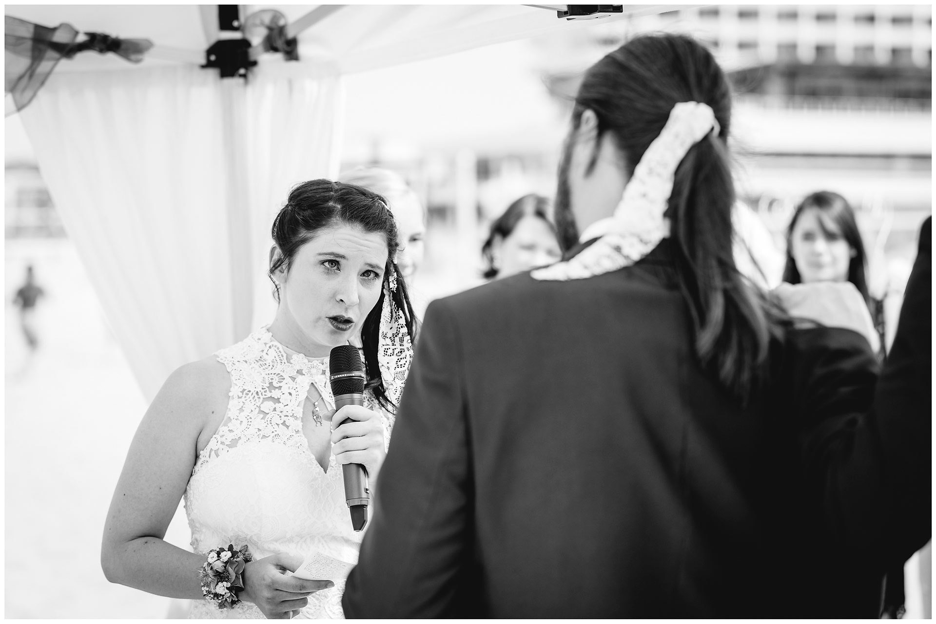 Braut-liest-ihrem-Mann-das-Eheversprechen-vor-Hochzeit-am-Strand-Hochzeitsfotograf-Warnemuende-Hochzeitsfotograf-Rostock-Hochzeitsfotograf-Ostseebad-Warnemuende