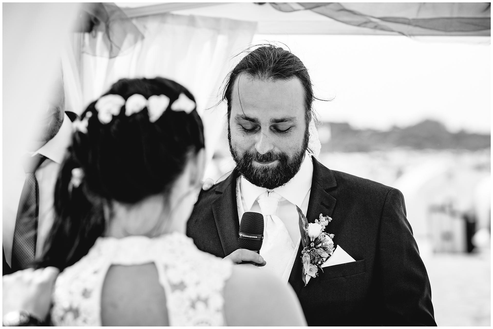 Braeutigam-liest-seiner-Frau-das-Eheversprechen-vor-Hochzeit-am-Strand-Hochzeitsfotograf-Warnemuende-Hochzeitsfotograf-Rostock-Hochzeitsfotograf-Ostseebad-Warnemuende