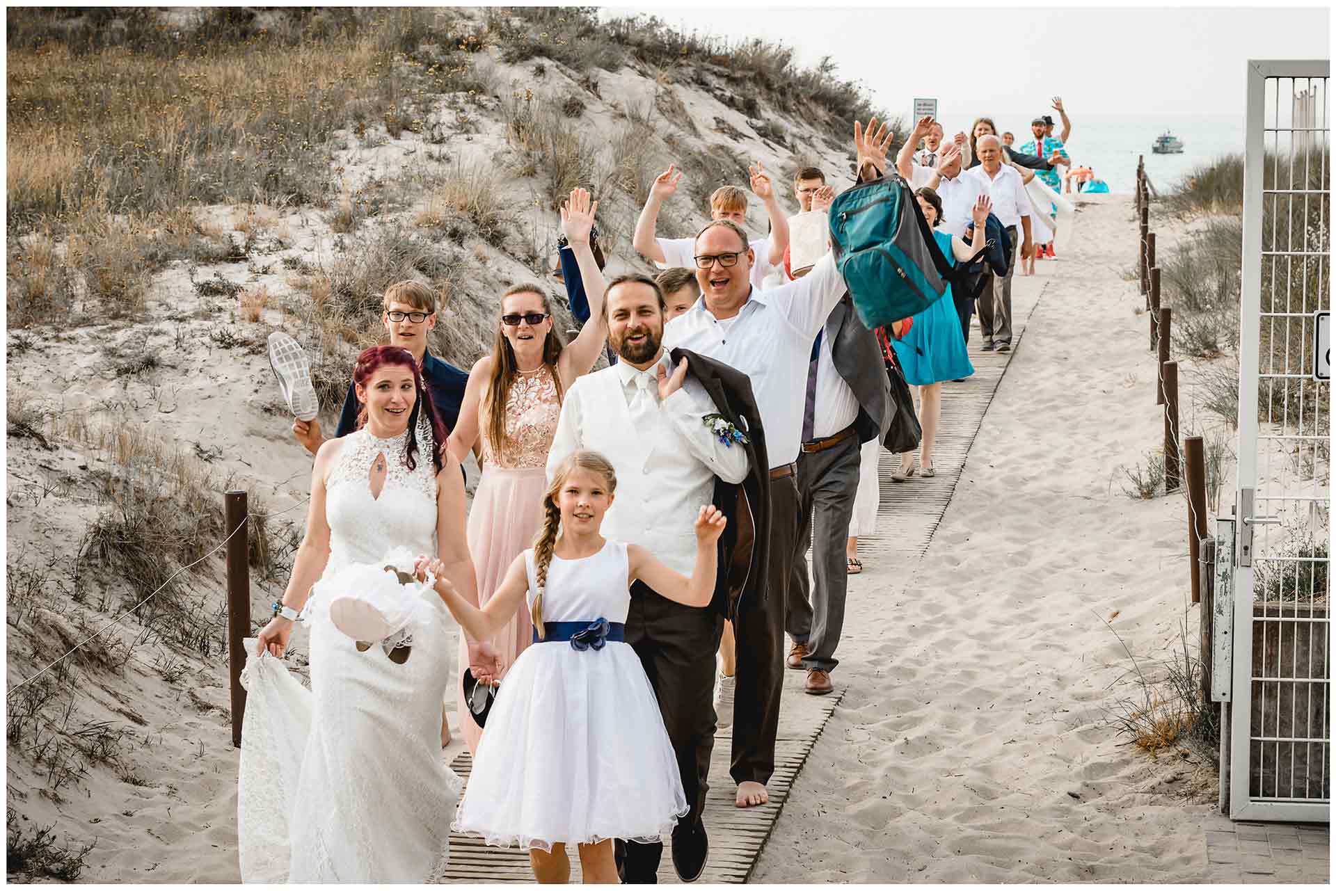 Brautpaar-und-Gaeste-gehen-nach-Freier-Trauung-am-Strand-zurueck-ins-Hotel-Neptun-Hochzeit-am-Strand-Hochzeitsfotograf-Warnemuende-Hochzeitsfotograf-Rostock-Hochzeitsfotograf-Ostseebad-Warnemuende