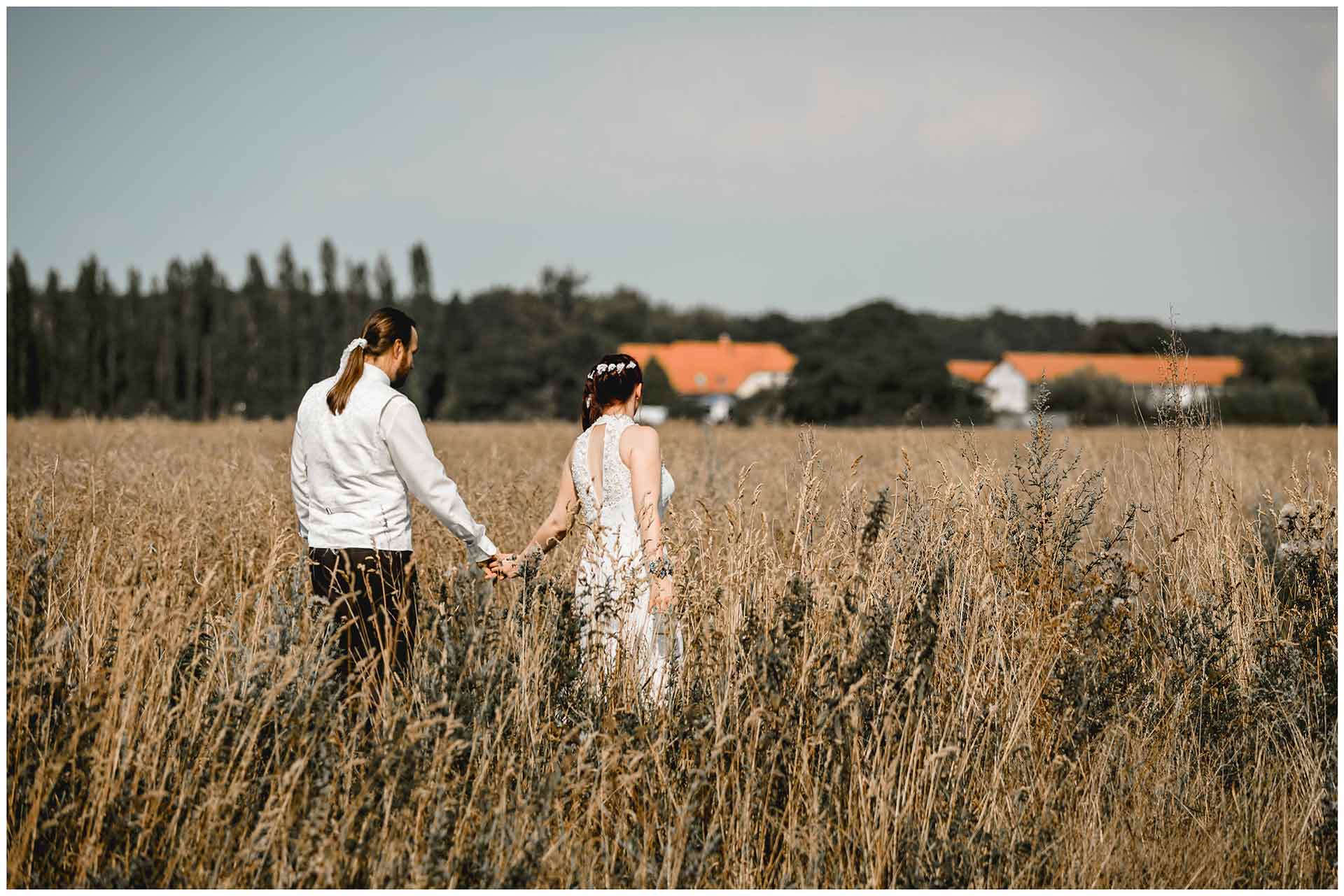 Hochzeitspaar-geht-im-Kornfeld-spazieren-Hochzeitsshooting-Hochzeit-am-Strand-Hochzeitsfotograf-Warnemuende-Hochzeitsfotograf-Rostock-Hochzeitsfotograf-Ostseebad-Warnemuende