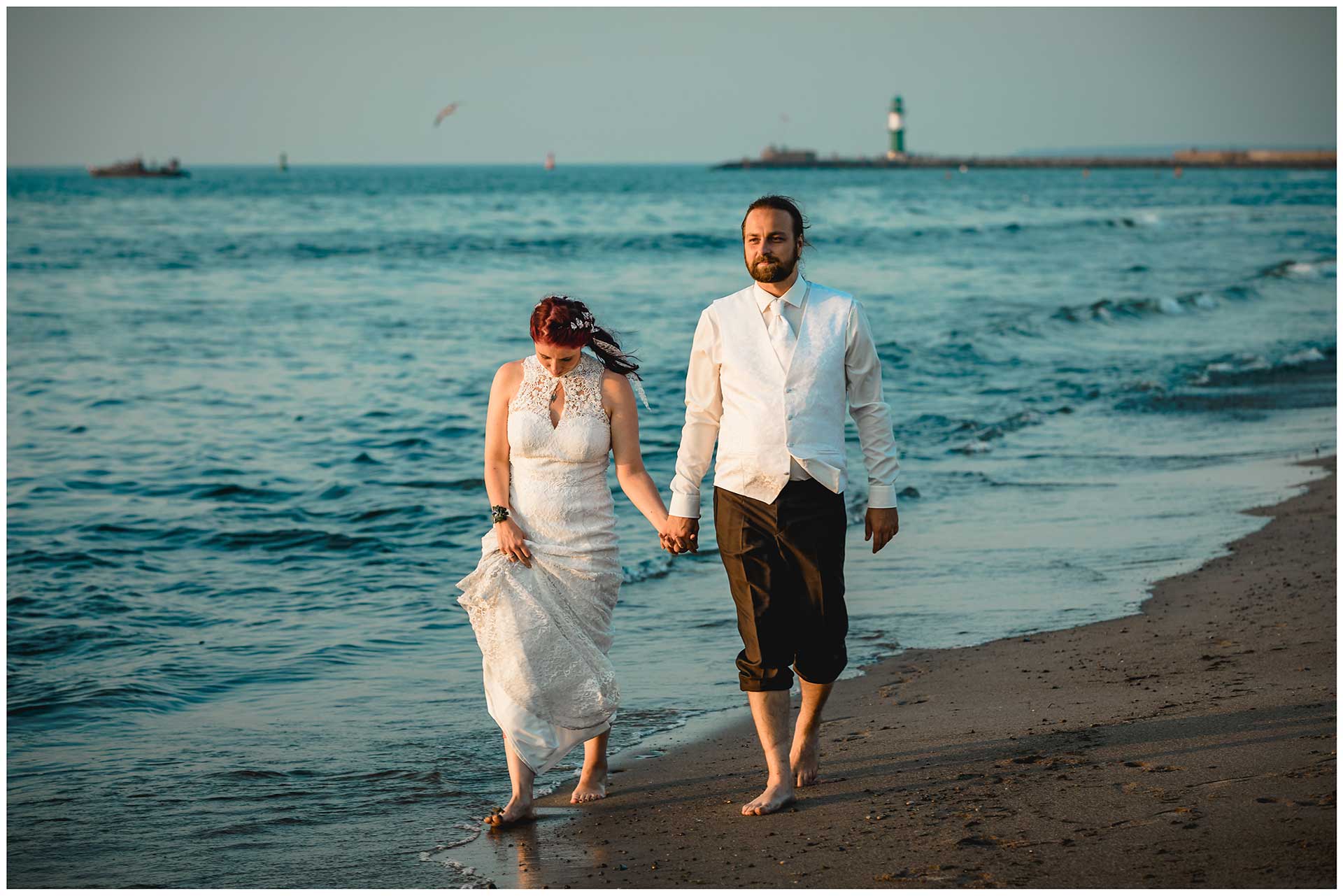 Brautpaar-geht-Barfuss-am-Strand-spazieren-Hochzeitsfotografie-Hochzeitsfotograf-Warnemuende-Hochzeitsfotograf-Rostock-Hochzeitsfotograf-Ostseebad-Warnemuende