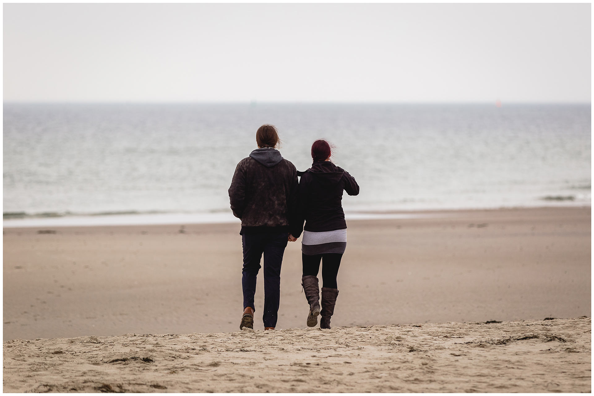 paar-von hinten-gehen-hand-in-hand-richtung-wasser-ostsee-shooting-am-strand-fotoshooting-paerchenbilder-fotograf-warnemuende-fotograf-rostock