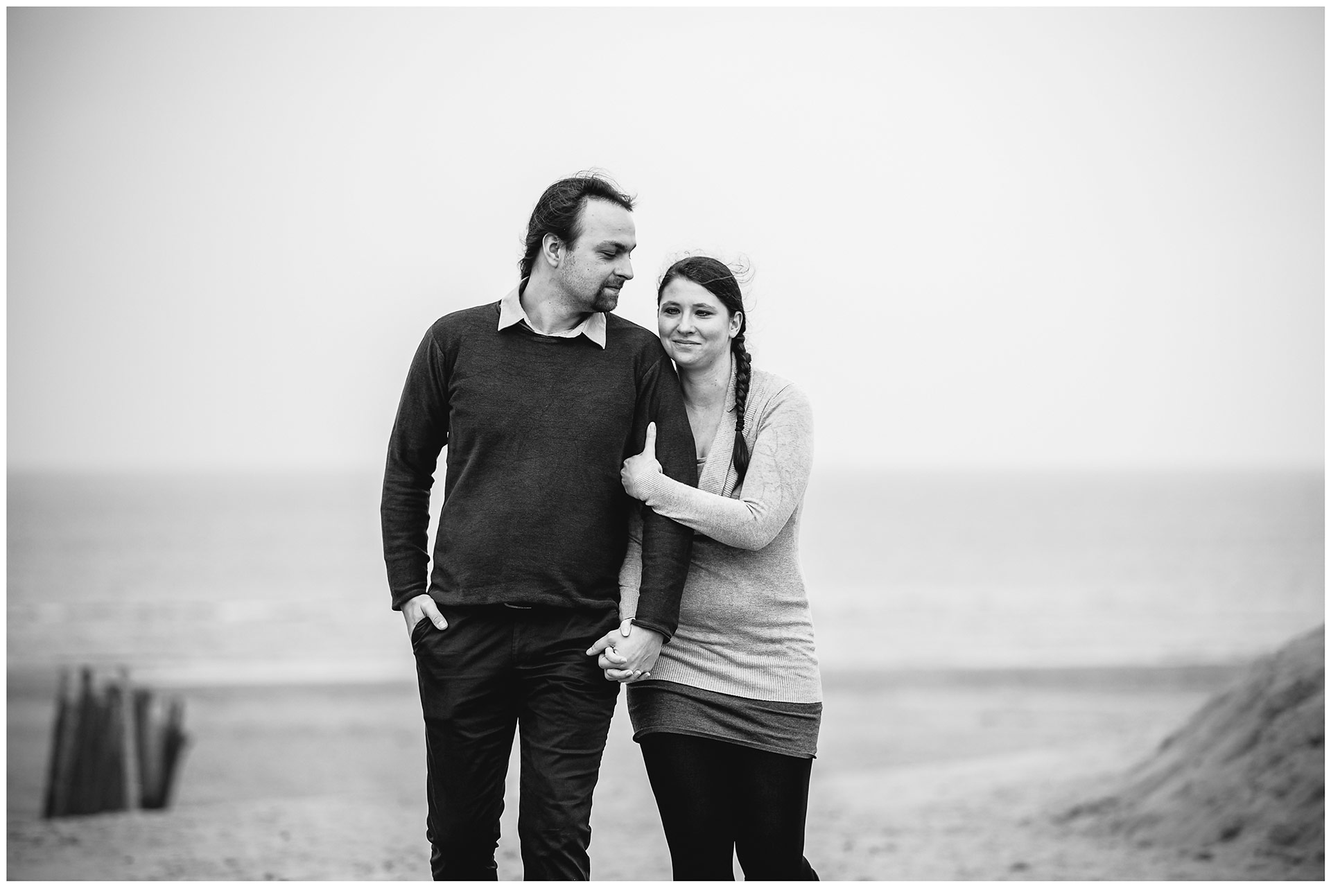 paar-geht-zusammen-am-strand-frau-laechelt-mann-guckt-frau-an-shooting-am-strand-paarshooting-fotograf-rostock-fotograf-warnemünde-paerchenbilder-fotoshooting