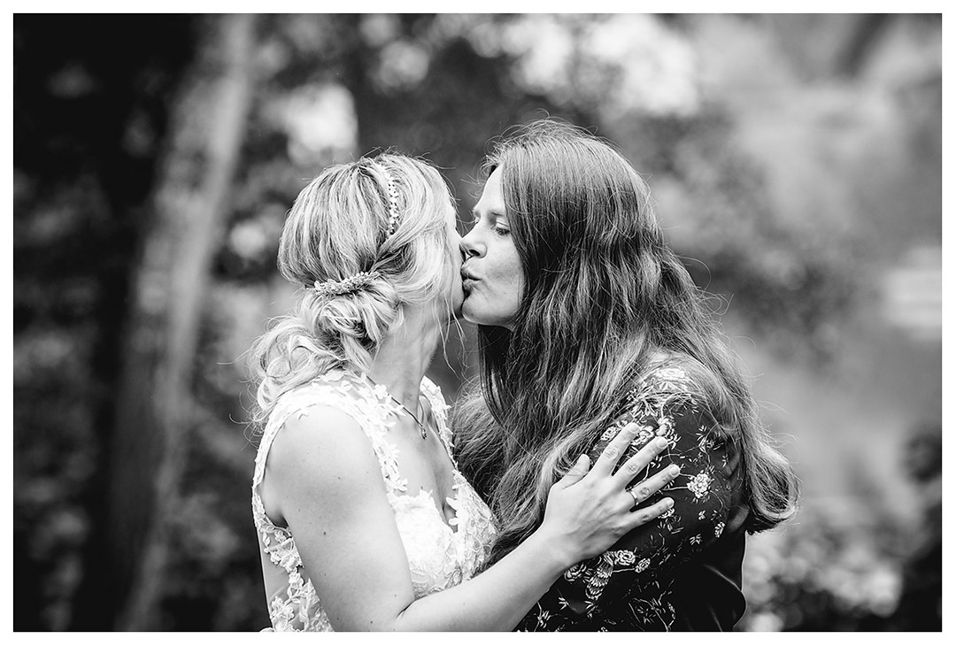 Hochzeitsfotograf - Braut bekommt Kuss von Schwester auf die Wange - Hochzeitsfotograf Villa Papendorf