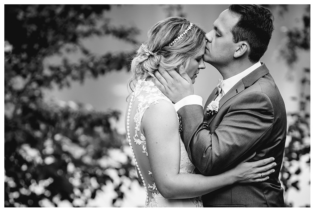 Hochzeitsfotograf Rostock - Brautpaarshooting - Bräutigam küsst Braut auf Stirn - Fotograf Rostock - Hochzeitsfotograf Villa Papendorf