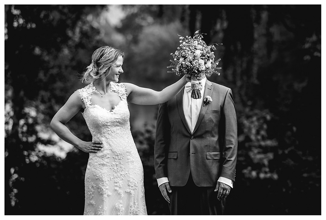 Hochzeitsfotograf Rostock - Brautpaarshooting - Braut hält lachend Brautstrauß vor Gesicht des Bräutigams - Fotograf Rostock - Hochzeitsfotograf Villa Papendorf