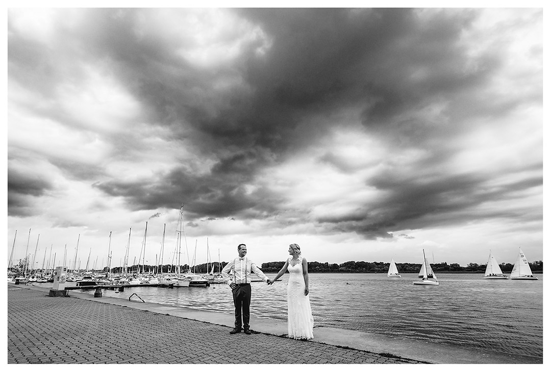 Brautpaar Hand in Hand am Ufer der Rostocker Warnow - Hochzeitsfotograf