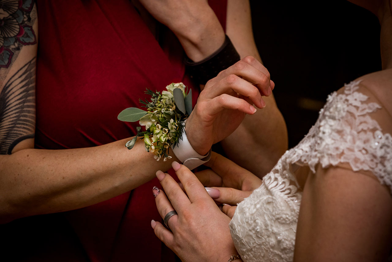 Braut legt Trauzeugin Blumenarmband an - Fotograf Hochzeit Schloss Bredenfelde