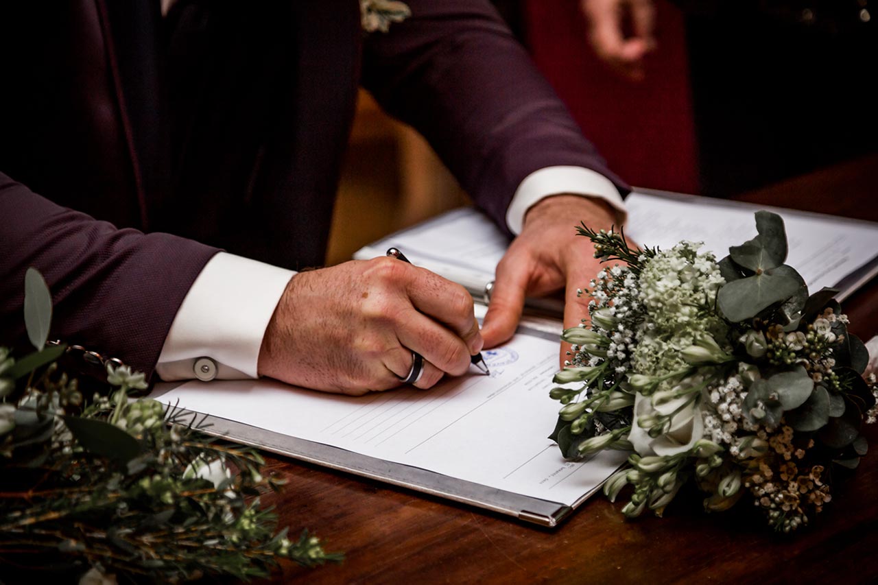 Nahaufnahme Bräutigam unterschreibt Eheurkunde - Hochzeitsfotograf Rostock