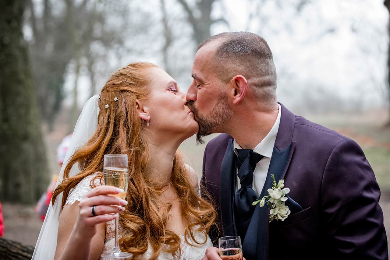 Brautpaar küsst sich und stößt mit Sekt an - Hochzeitsfotograf Bredenfelde