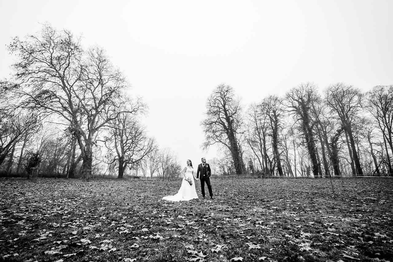 Weitwinkelaufnahme Brautpaar steht auf Wiese - Hochzeitsshooting - Hochzeitsfotografie - Hochzeitsfotograf Bredenfelde