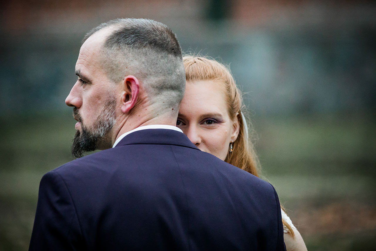 Nahaufnahme Braut schaut über Schulter des Bräutigams - Hochzeitsshooting - Hochzeitsfotografie - Hochzeitsfotograf Bredenfelde